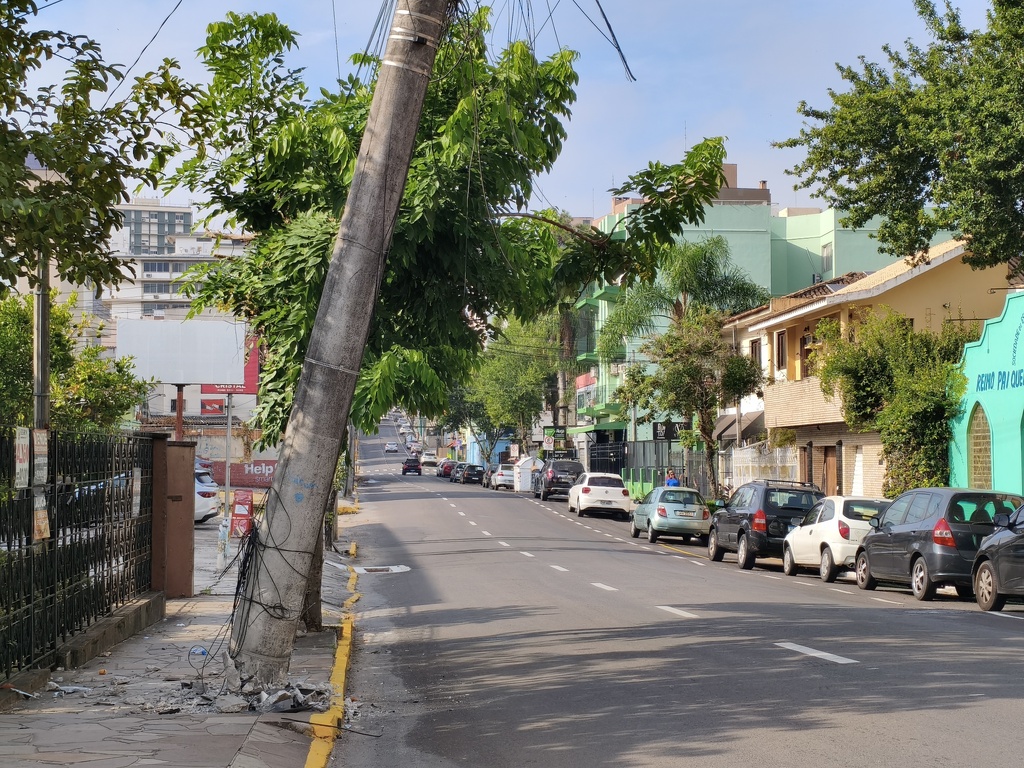 Poste danificado fica pendurado pelos fios na Rua Duque de Caxias e mobiliza equipe da RGE