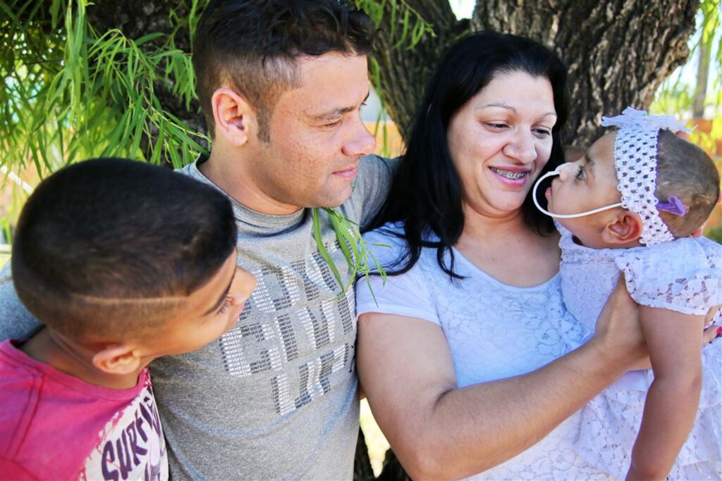 Foto: Renan Mattos (Diário) - Bianca (no colo) conta com o carinho do irmão, Marcos Henrique, da mãe, Tieli, e do pai, Marcos Renato