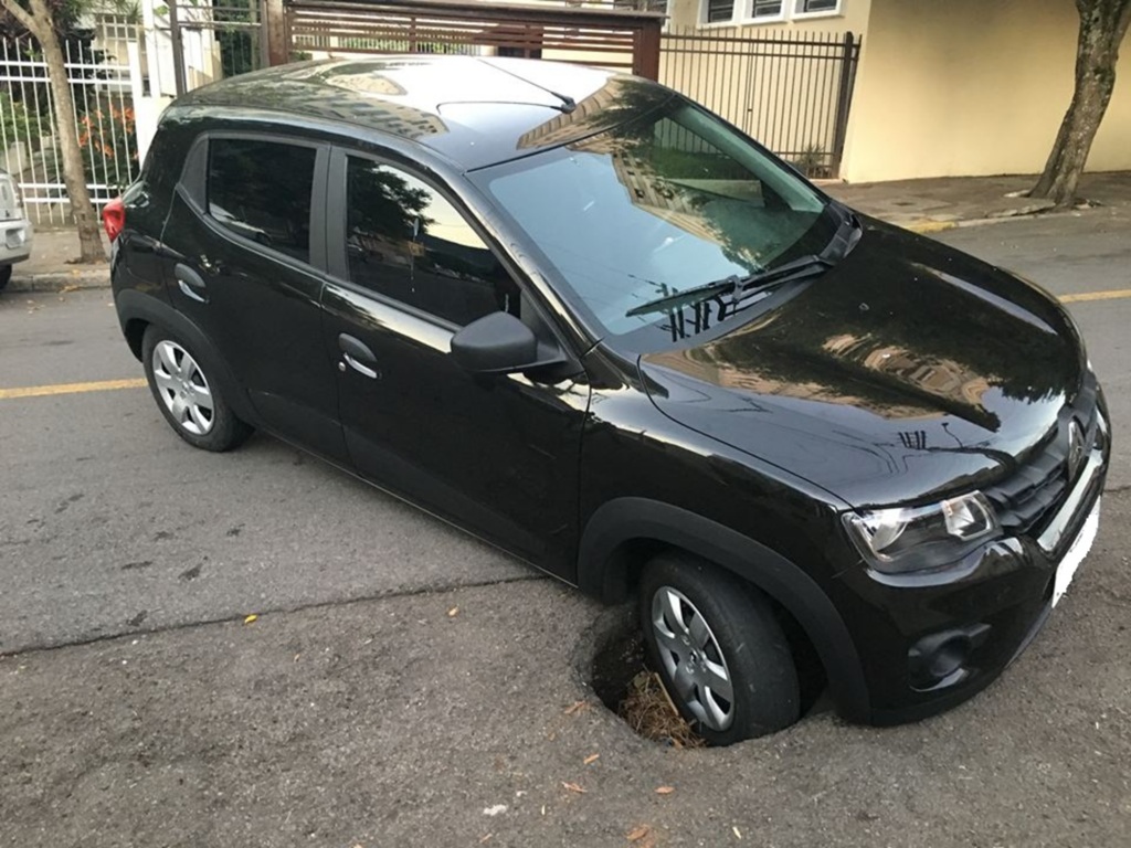 Buraco 'engole' roda de carro em rua de Santa Maria