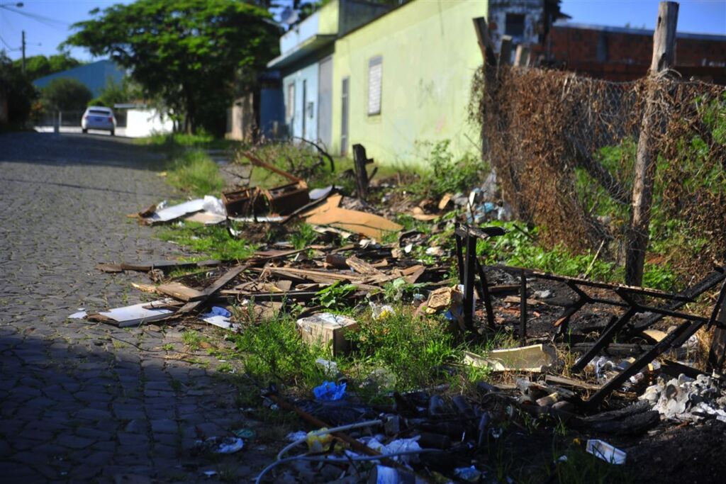 Fotos Gabriel Haesbaert - Terreno na Rua Samuel Kruschim (acima) virou depósito de lixo dos vizinhos. Casa na Rua das Açucenas está cheia de entulhos