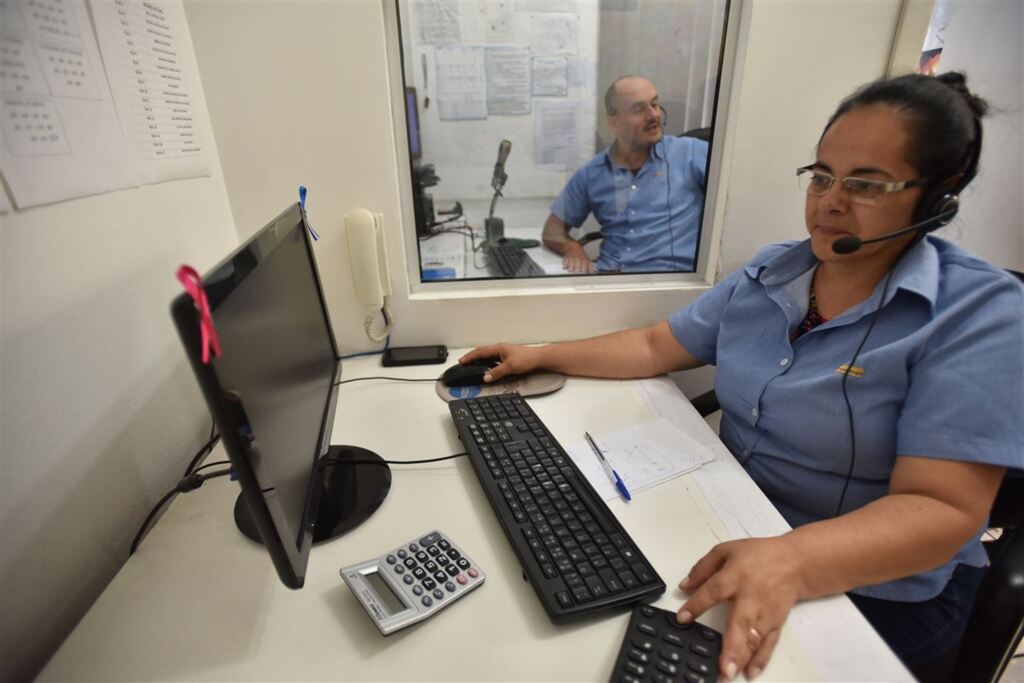 - A telefonista Marcia atende as chamadas dos passageiros e passa as coordenadas ao operador Marcus Vinicius (ao fundo)