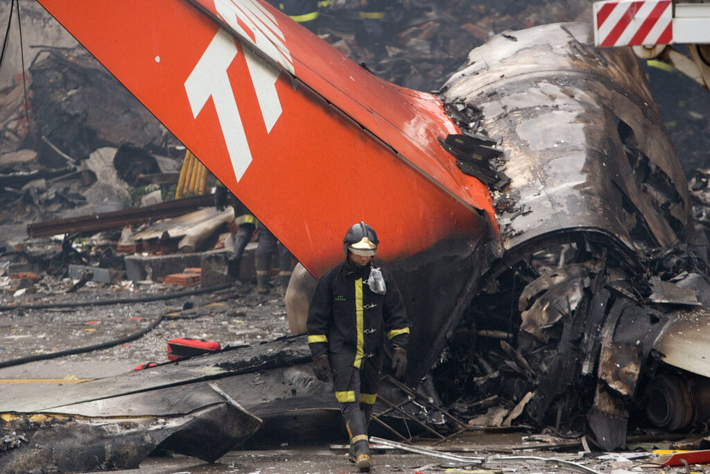AP - A firefighter walks in front of a TAM airlines commercial jet that crashed in Sao Paulo, Wednesday, July 18, 2007. Rescue crews pulled dozens of bodies Wednesday from a Brazilian airliner that crashed and burst into flames at Brazil's busiest airport, as the number of people feared dead rose to 195.  (AP Photo/Victor R. Caivano)