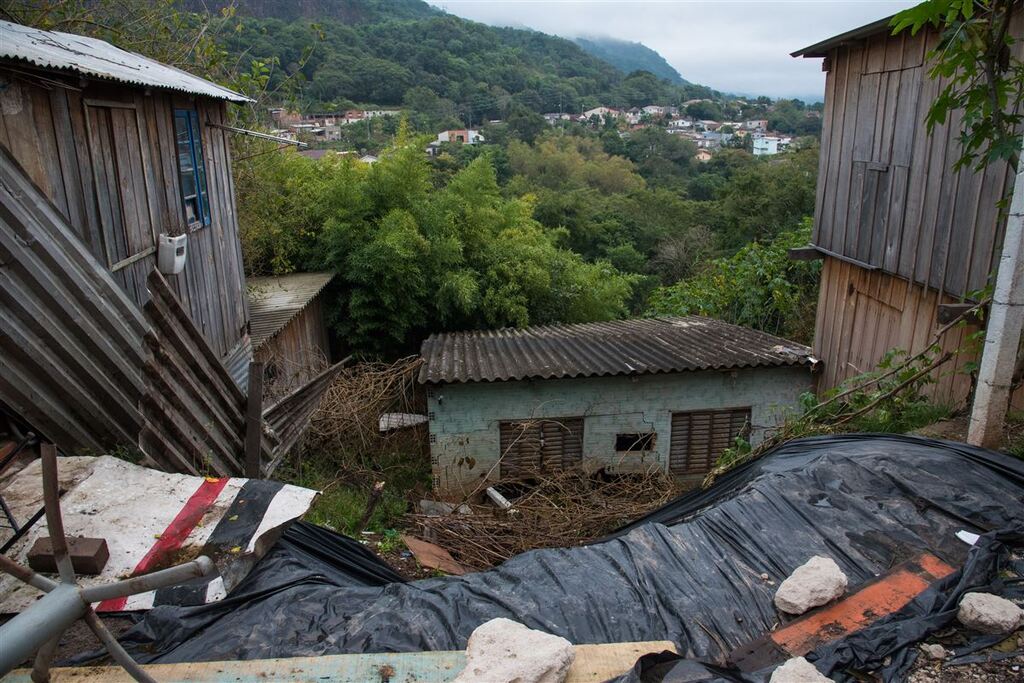 Foto: Eduardo Ramos (Diário) - Barranco que desabou e atingiu uma casa na Rua dos Canários, no início de maio. Lonas são colocadas pela Defesa Civil como técnica para evitar mais deslizamentos