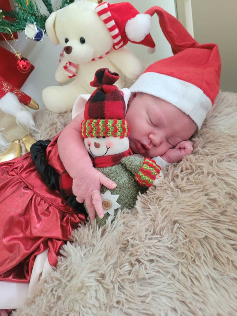 Foto: Divulgação - Na foto, a pequena Isabella dorme abraçada em um boneco de neve.
