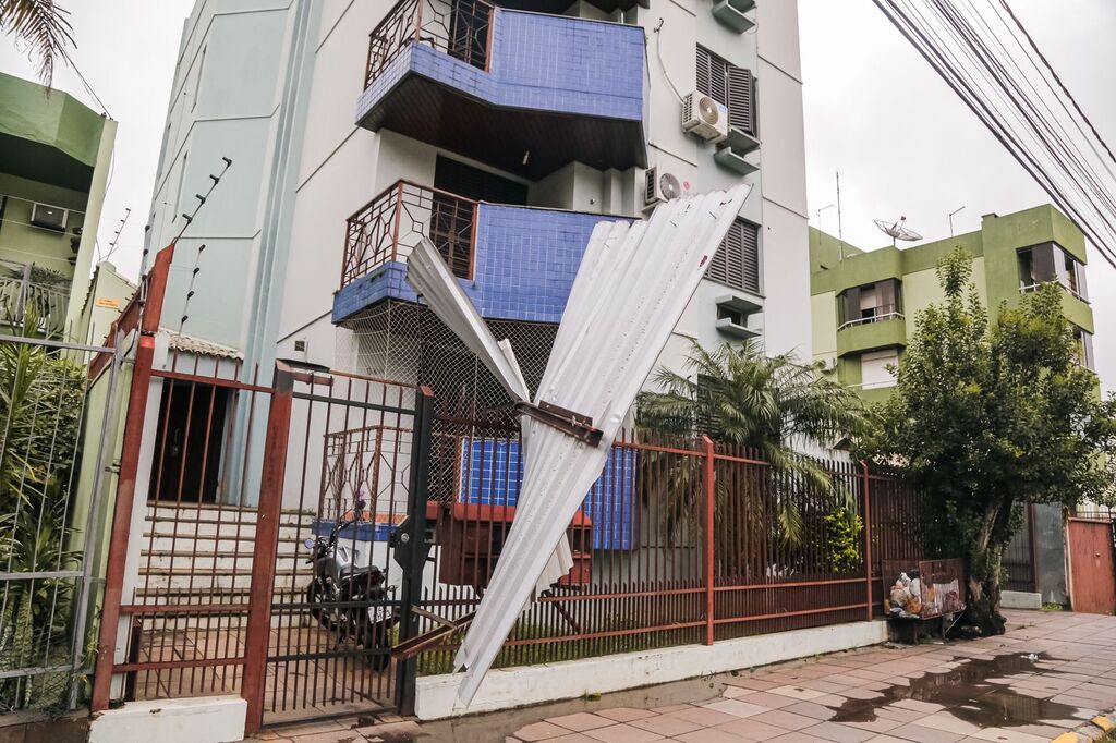 Fios de rede elétrica caem e telha fica presa em portão de rua no Bairro Nonoai Fios de rede elétrica caem e telha fica presa em portão de rua no Bairro Nonoai