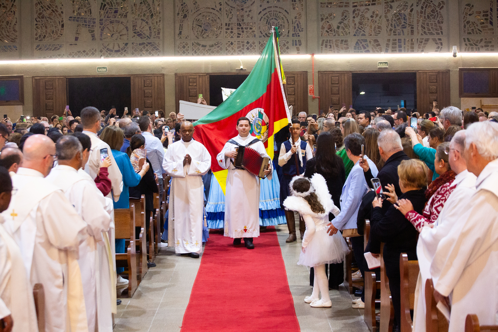 Galeria de imagens: Na entrada, a coroa foi carregada por pessoas trajadas com vestimentas do Rio Grande do Sul