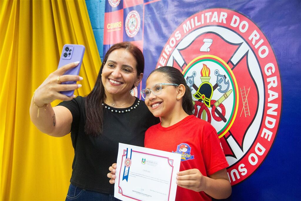 Galeria de imagens: Orgulhosa, Luciana (à esq.) registra a conquista da filha Ysadora, que se formou como Bombeira Mirim